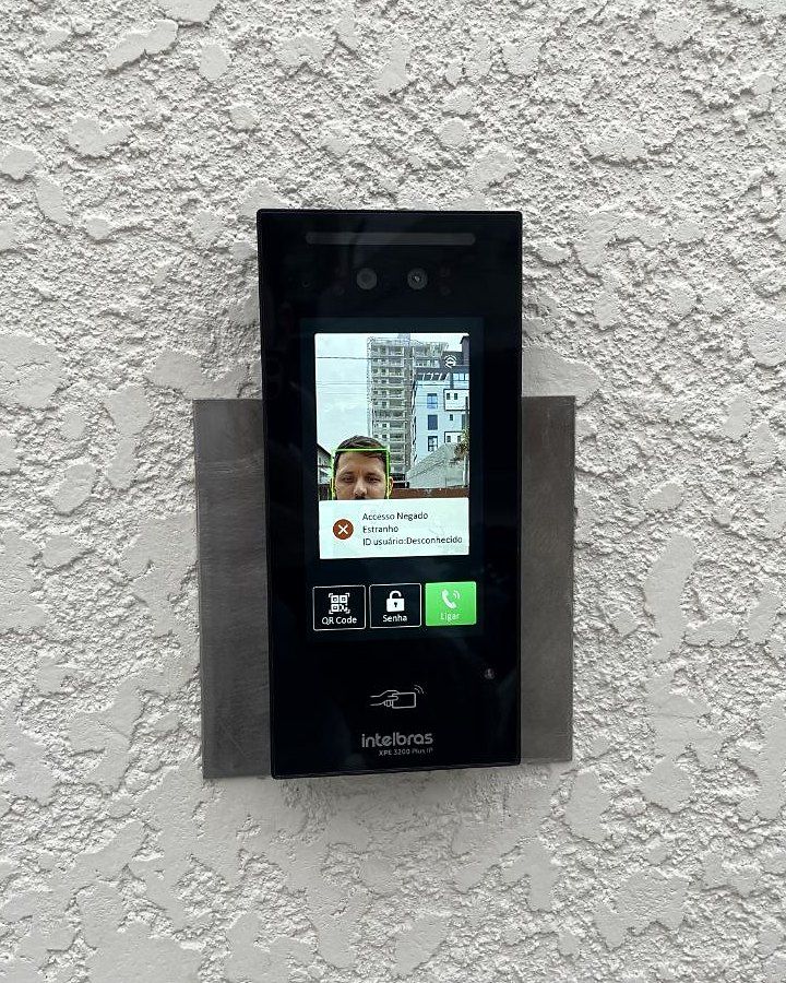 Leitor facial instalado pela Tristan sobre placa de acabamento em parede externa