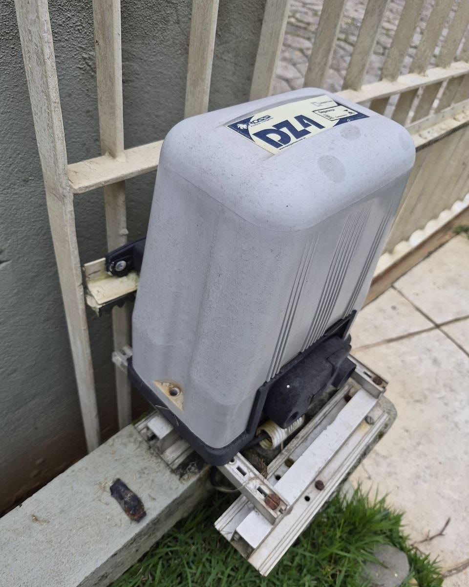 Motor de portão deslizante de outra marca, instalado junto a um portão de grade, atendido pela Tristan
